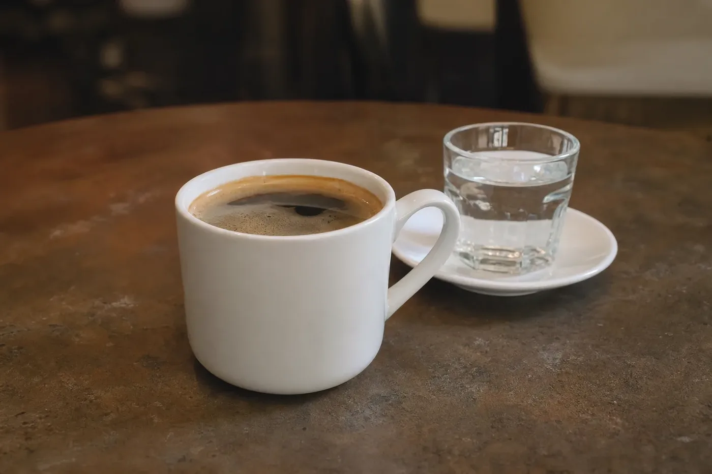 An americano in a white mug with a thin layer of crema