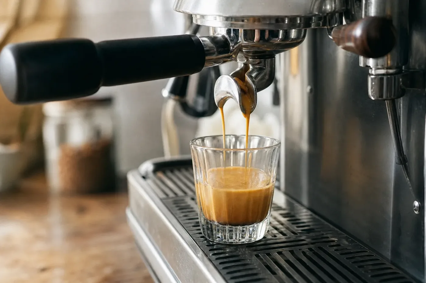 A blonde espresso shot with pale golden crema pouring into a small glass