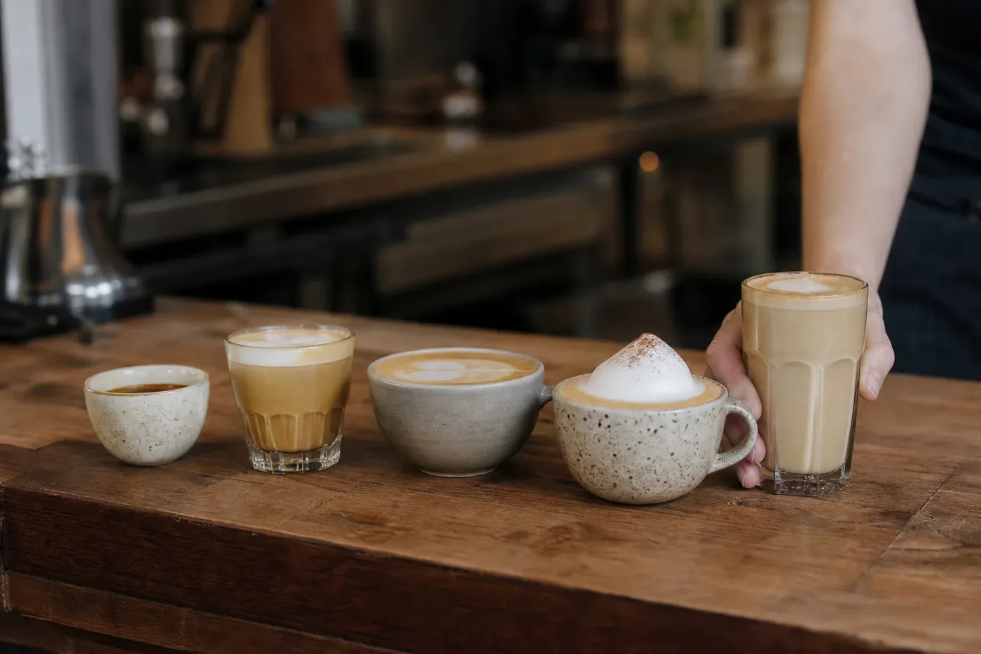 Espresso drinks lined up on a cafe counter from espresso to latte by amount of milk