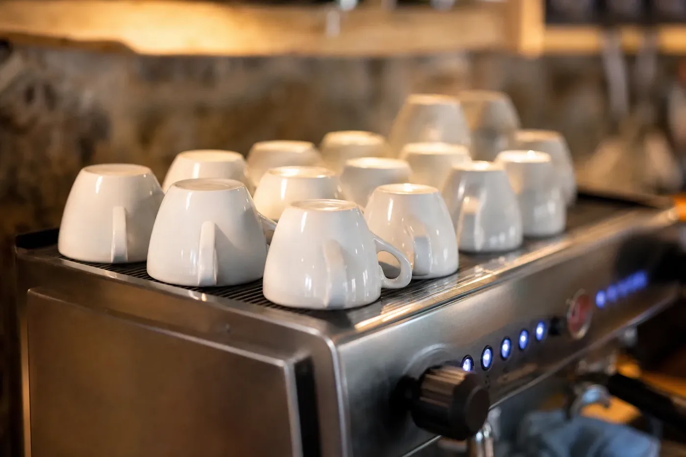 Demitasse cups warming on top of an espresso machine