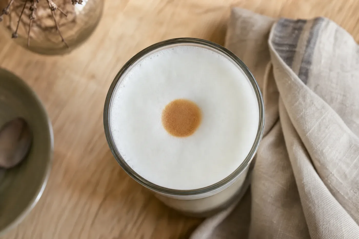 Looking down into a latte macchiato at the brown mark where the espresso went in