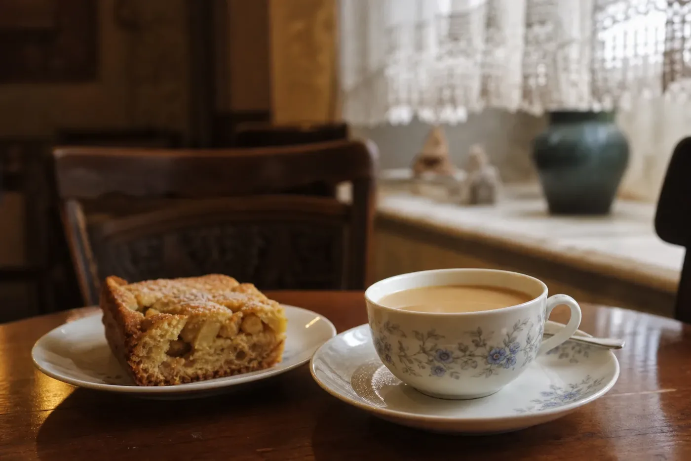 A cup of milky grain coffee with apple cake in a traditional Polish cafe
