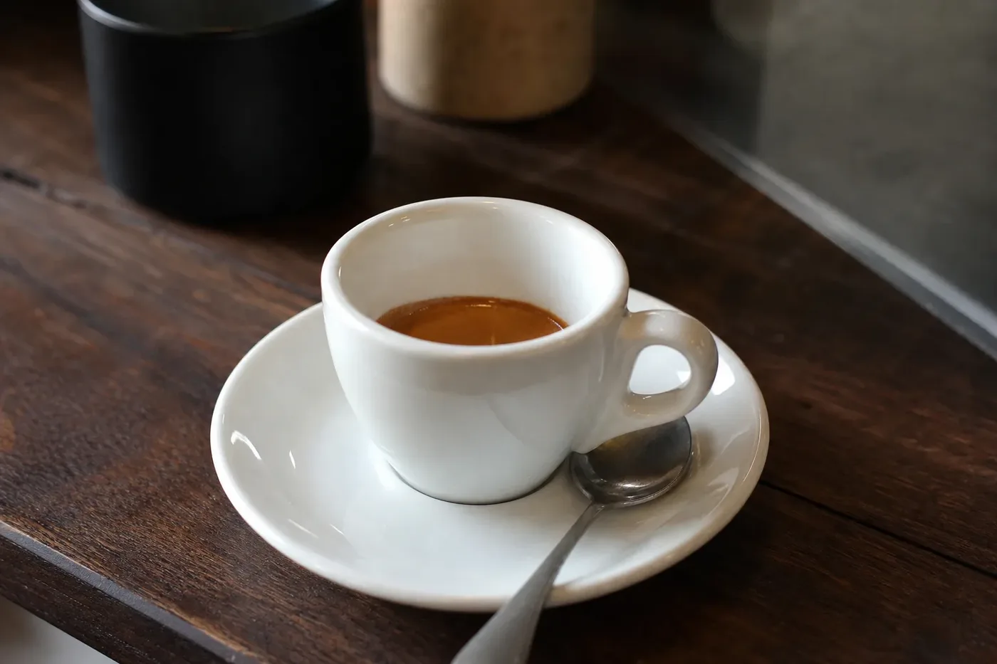 A very short ristretto with thick crema in a small white espresso cup
