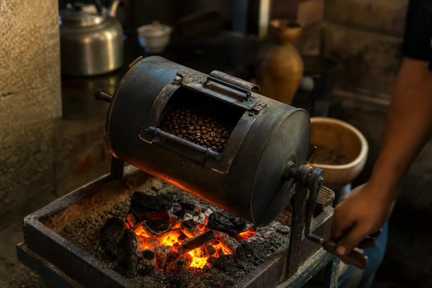 Coffee beans roasting in a small drum over glowing charcoal