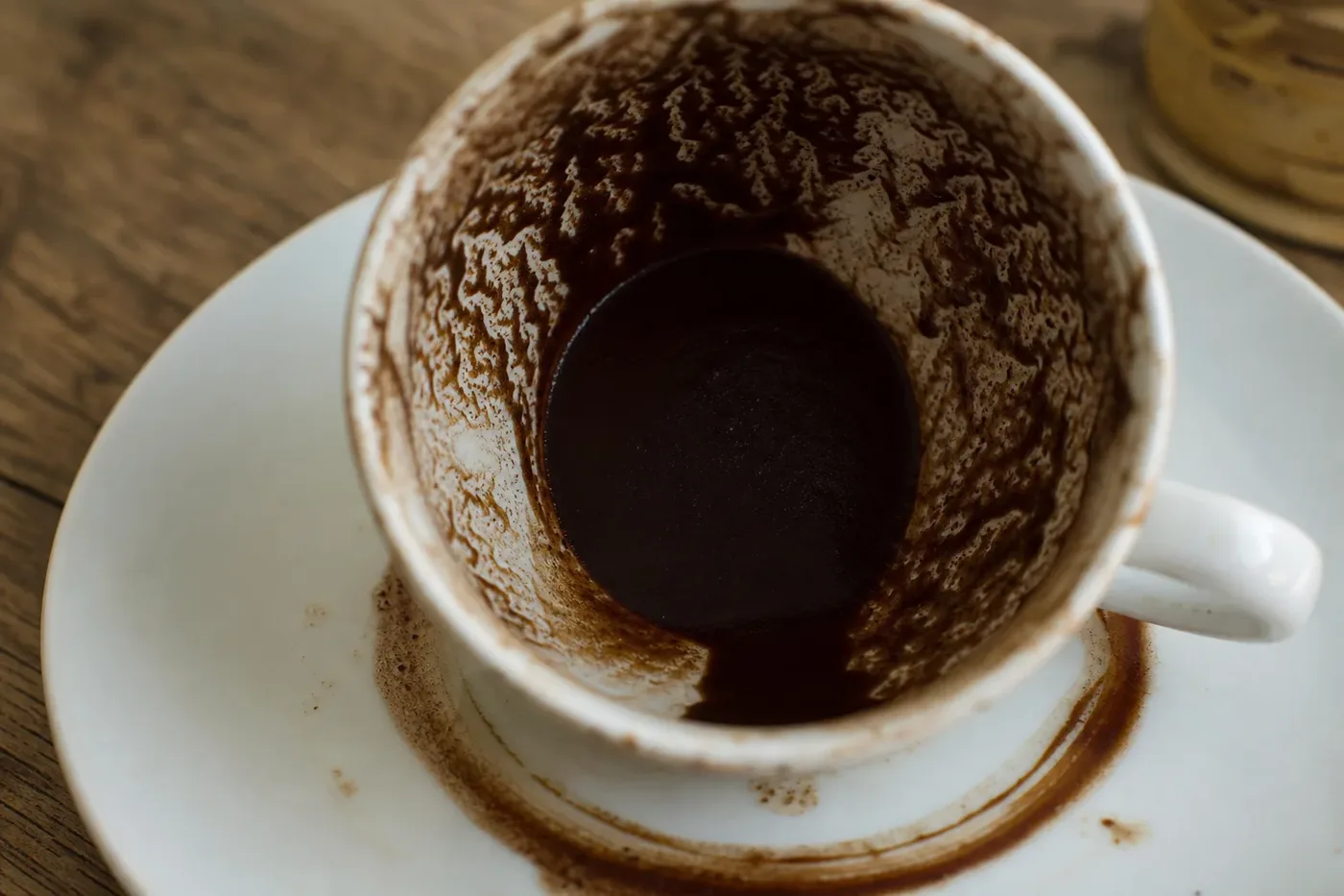 Patterns of dried coffee grounds on the inside of an empty Turkish coffee cup