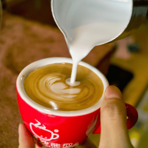 Barista making a Breve coffee with art