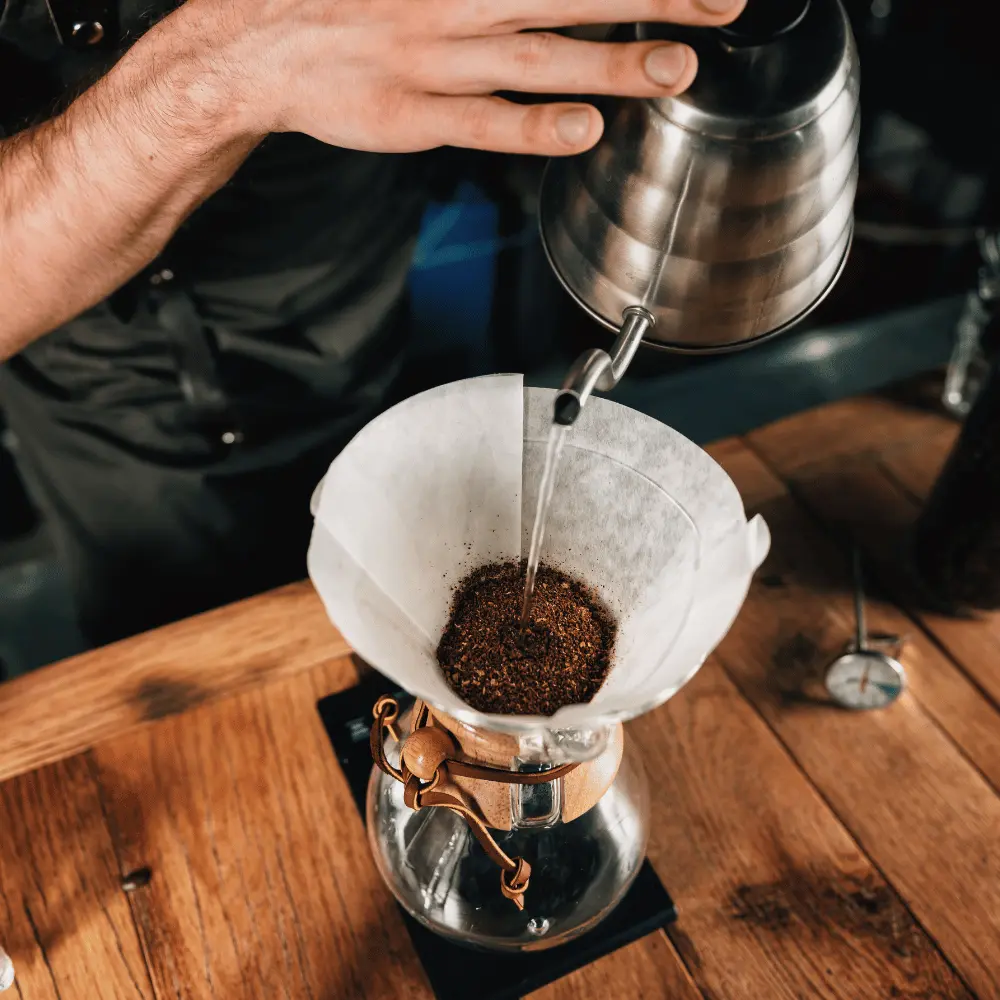 man brewing pour over coffee with a gooseneck kettle