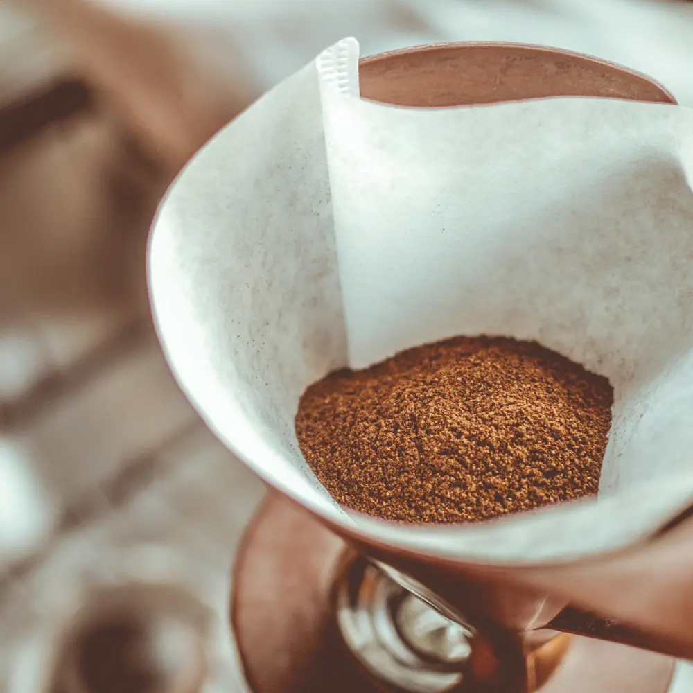 dry coffee grounds in a paper coffee filter ready for pour over