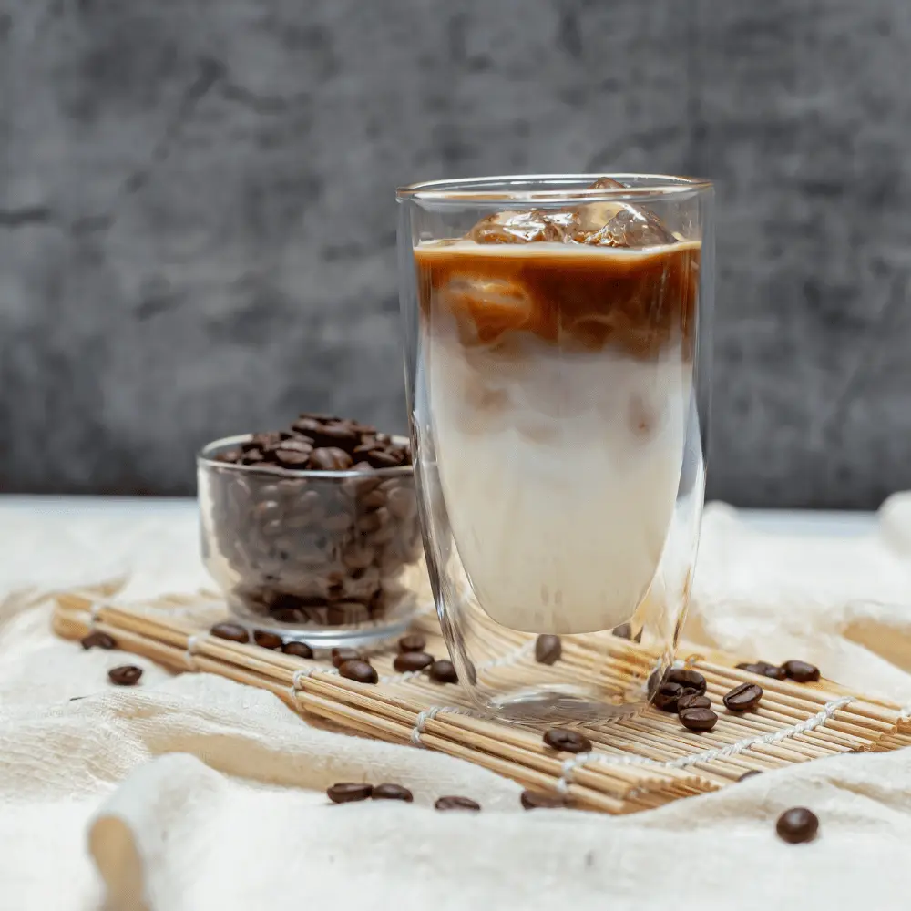 iced caramel macchiato with coffee beans on the table
