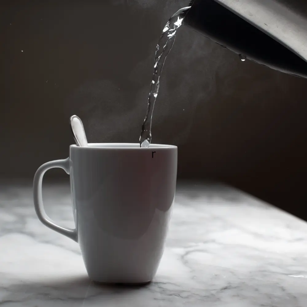 pouring hot water in a mug with spoon