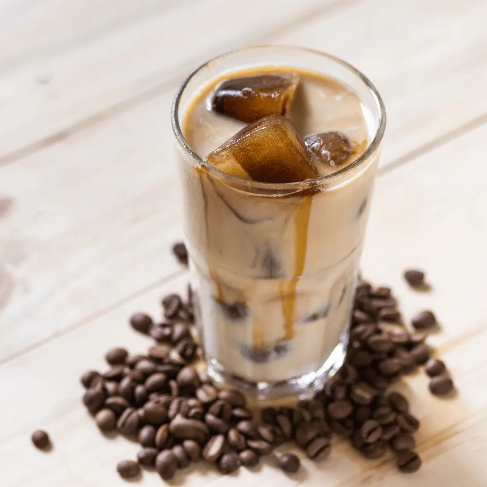iced coffee in a tall glass with roasted coffee beans