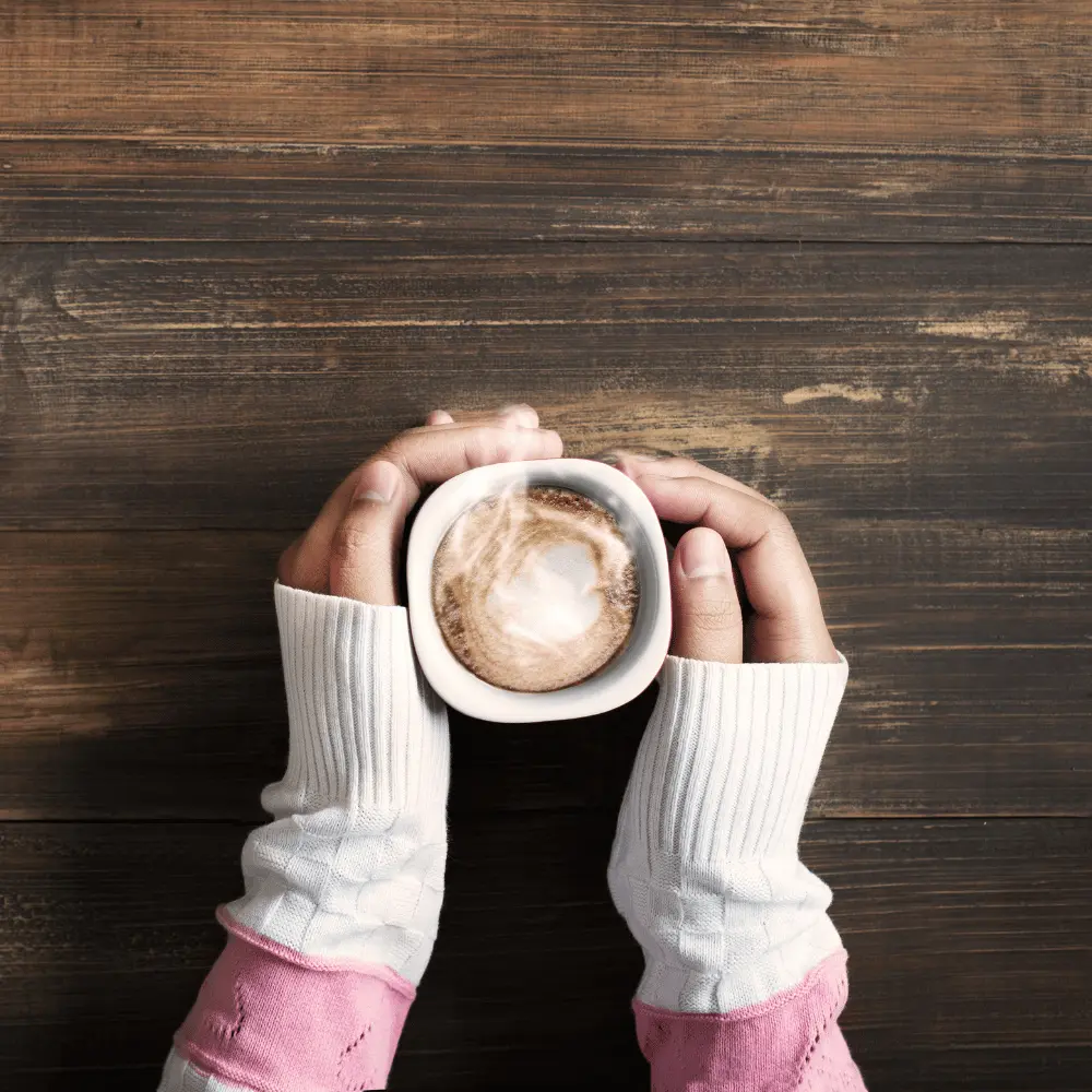 hands warming up with a hot cup of joe