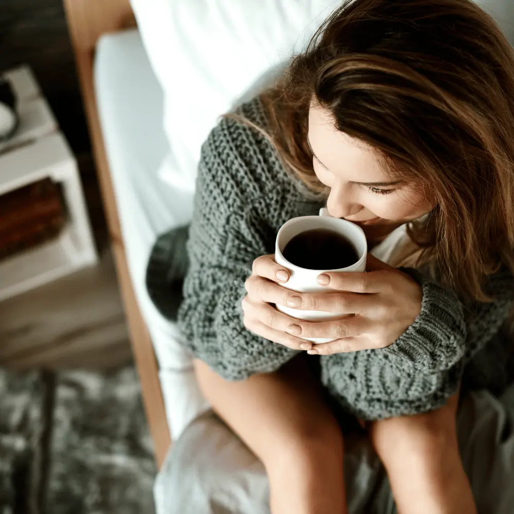 young woman enjoying a cup of coffee wondering if coffee is gluten free