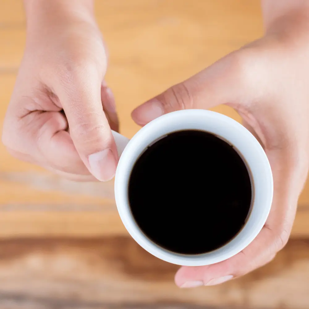 hands holding a cup of maca coffee