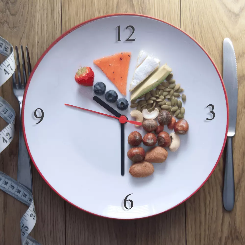 keto foods in a clock plate with measuring tape and knife and fork