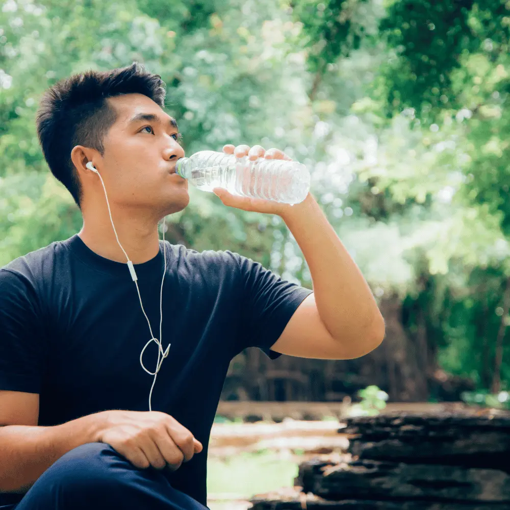 man drinks water while listening to music