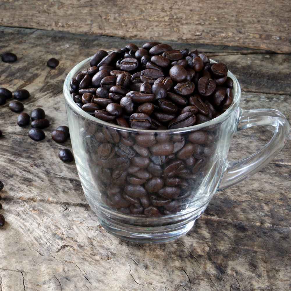 glass of dark roast coffee beans