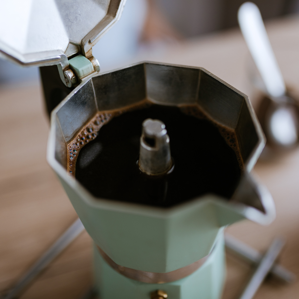 teal moka pot brewing coffee