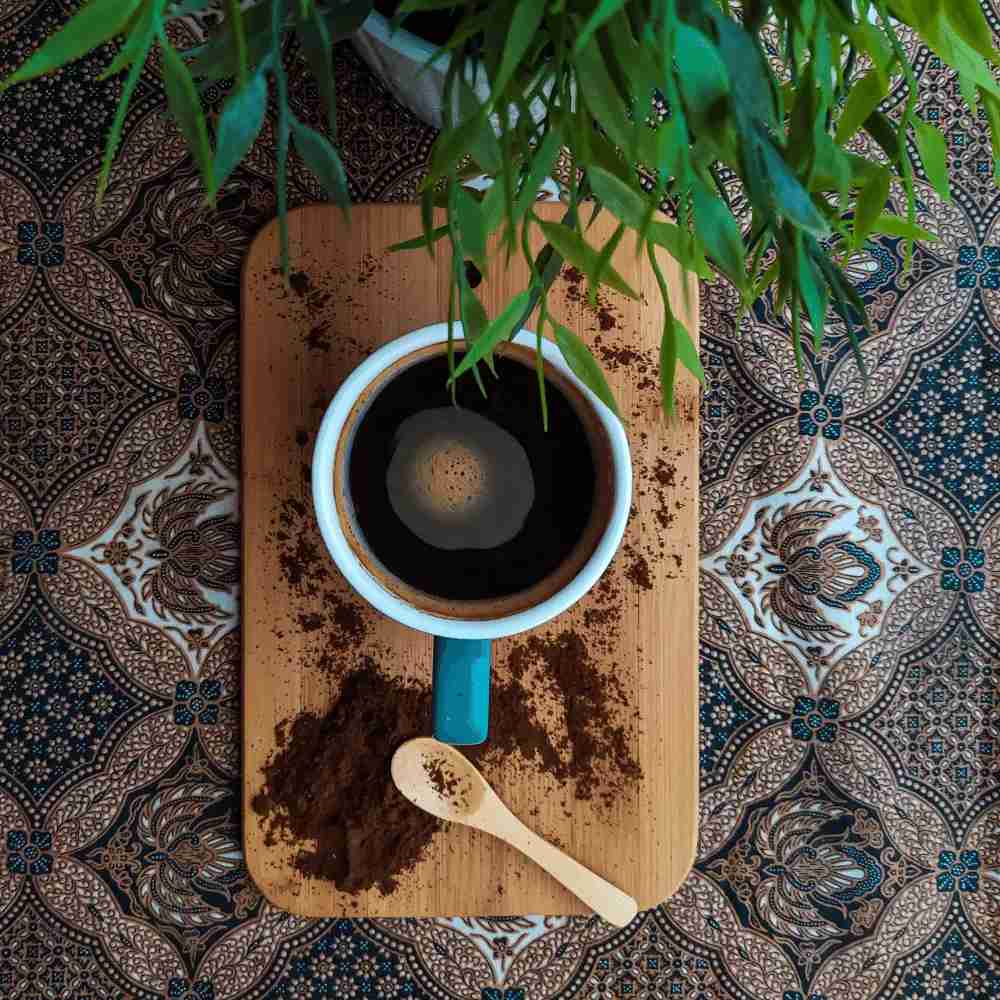 black eye coffee on a wooden table with a spoon and a plant