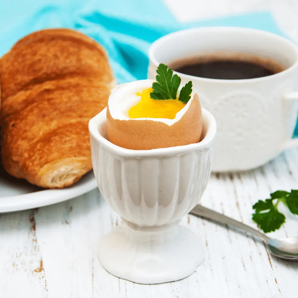 black eye coffee served with a soft boiled egg and a croissant