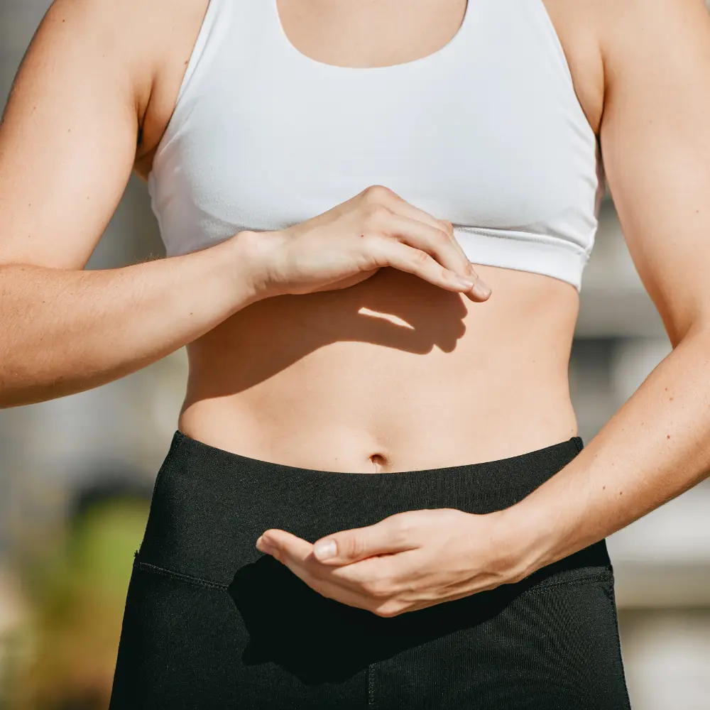 woman in workout clothing pretending to hold her stomach