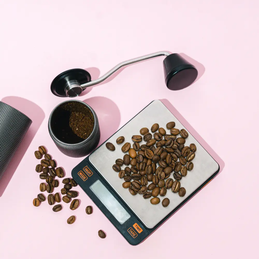 a coffee scale and coffee beans and a grinder