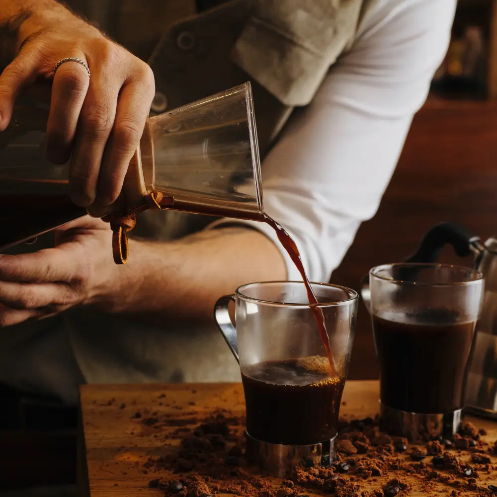 man pouring coffee from a chemx coffee maker