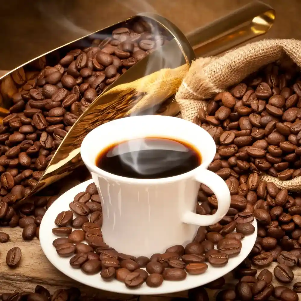 a steaming cup of coffee with coffee beans