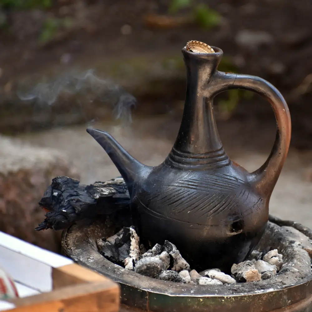 a pot of coffee sitting on hot coal