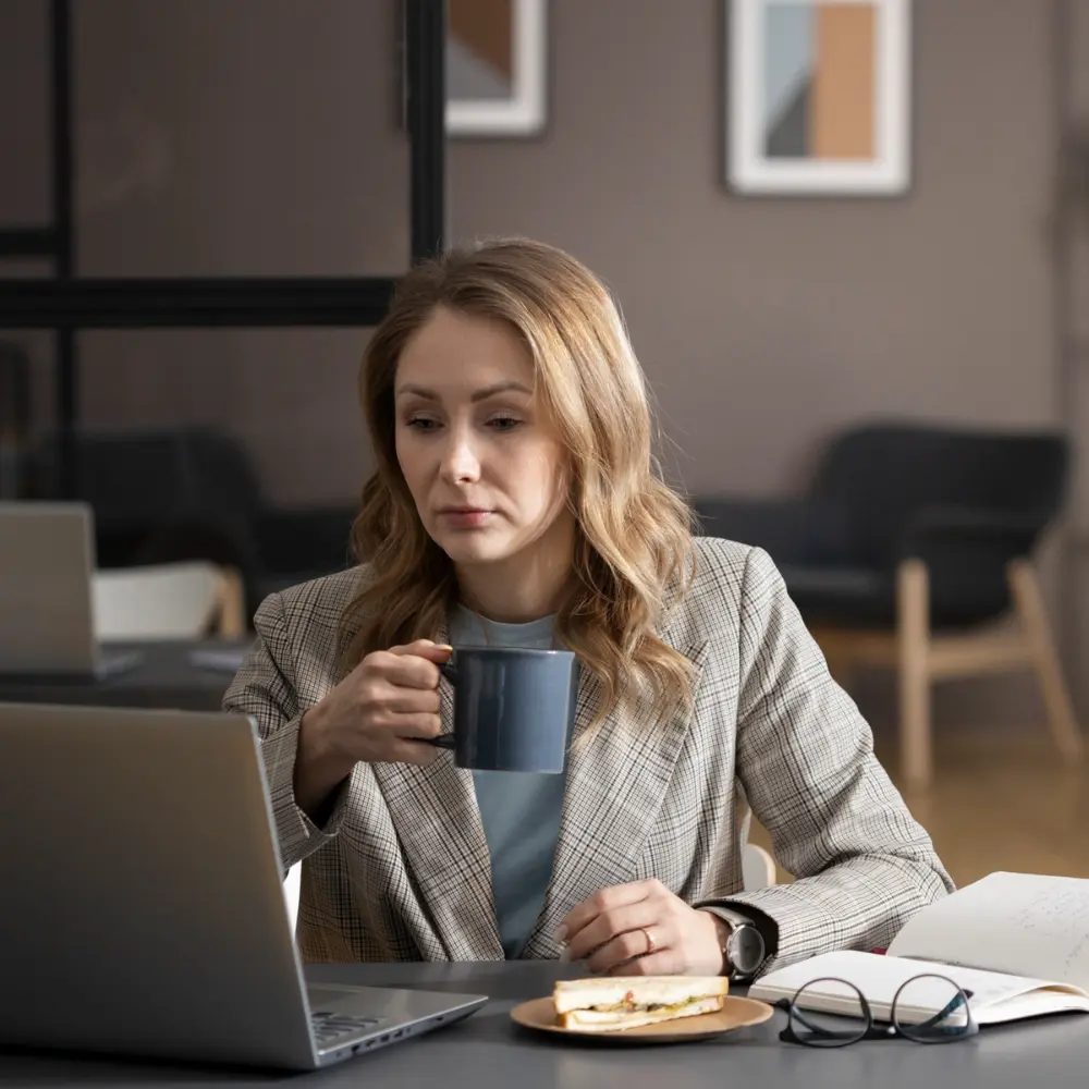 woman drinking coffee at work