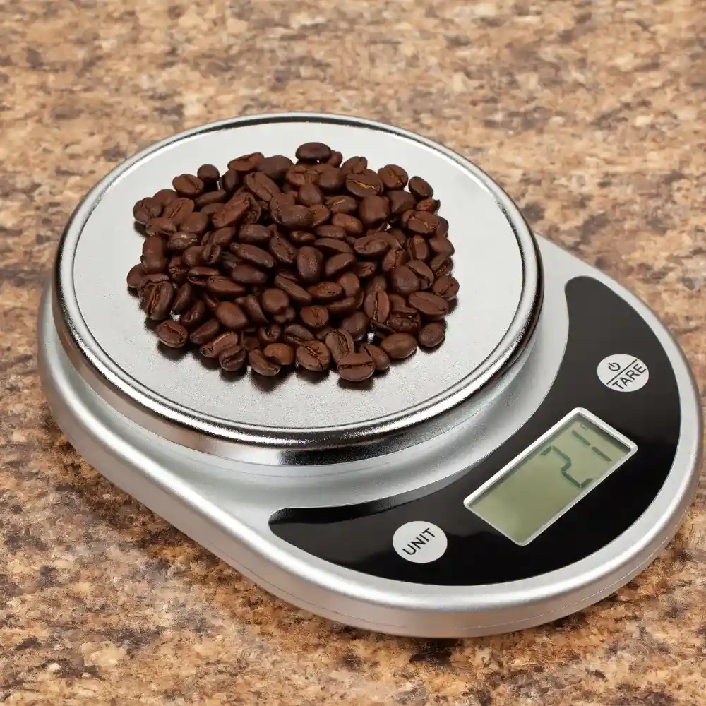 a coffee scale with some coffee beans measuring the coffee-to-water ratio