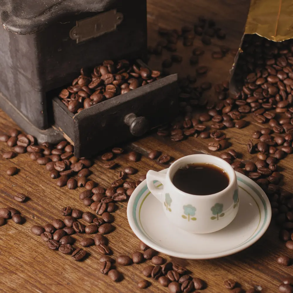 a cup of coffee and an old grinder wit