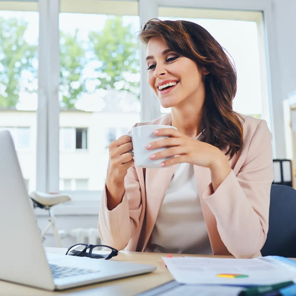 happy woman working from home holding a mug