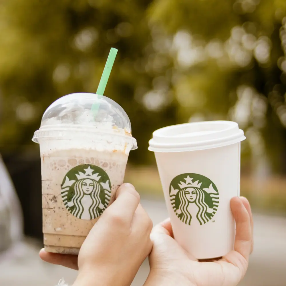 couple holding their starbucks cups