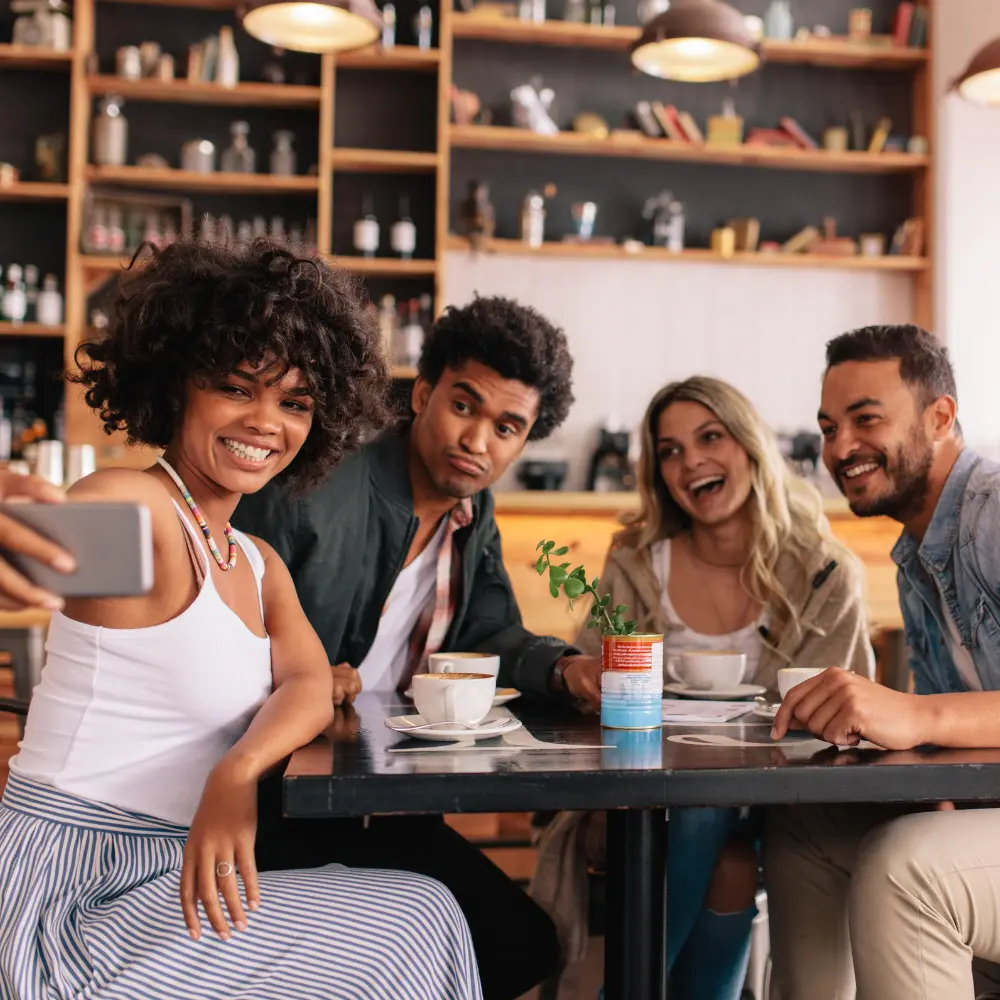 a group of young adults hanging out in a cafe and drinking coffee