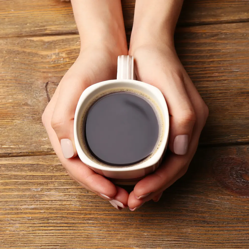 woman holding a cup of unfiltered coffee