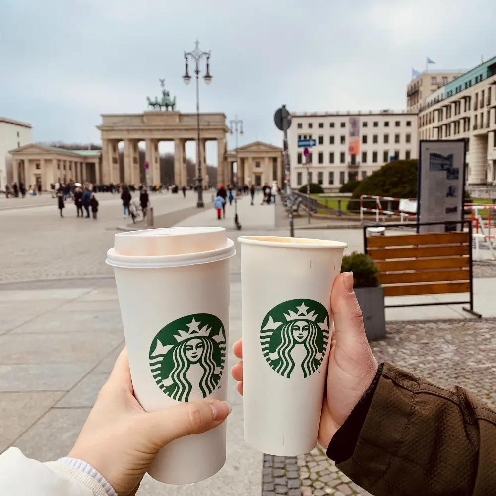 a couple holding starbucks in berlin