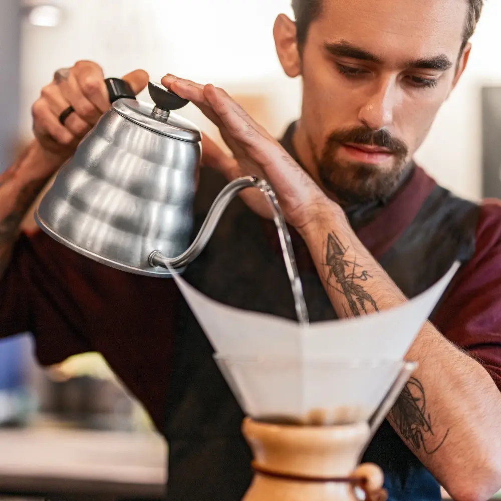 man brewing pour over coffee using a gooseneck kettle