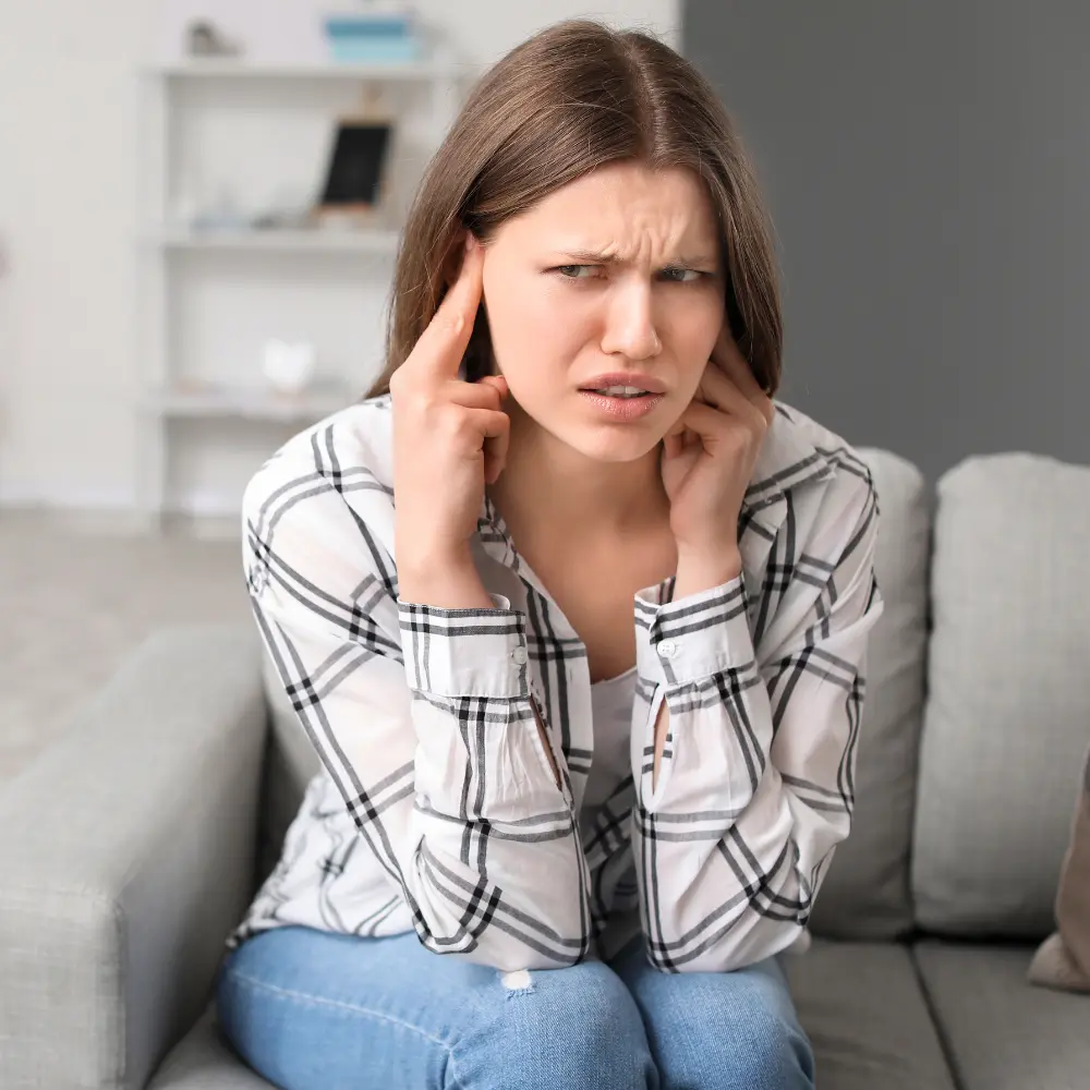 woman pressing on her ears because of tinnitus