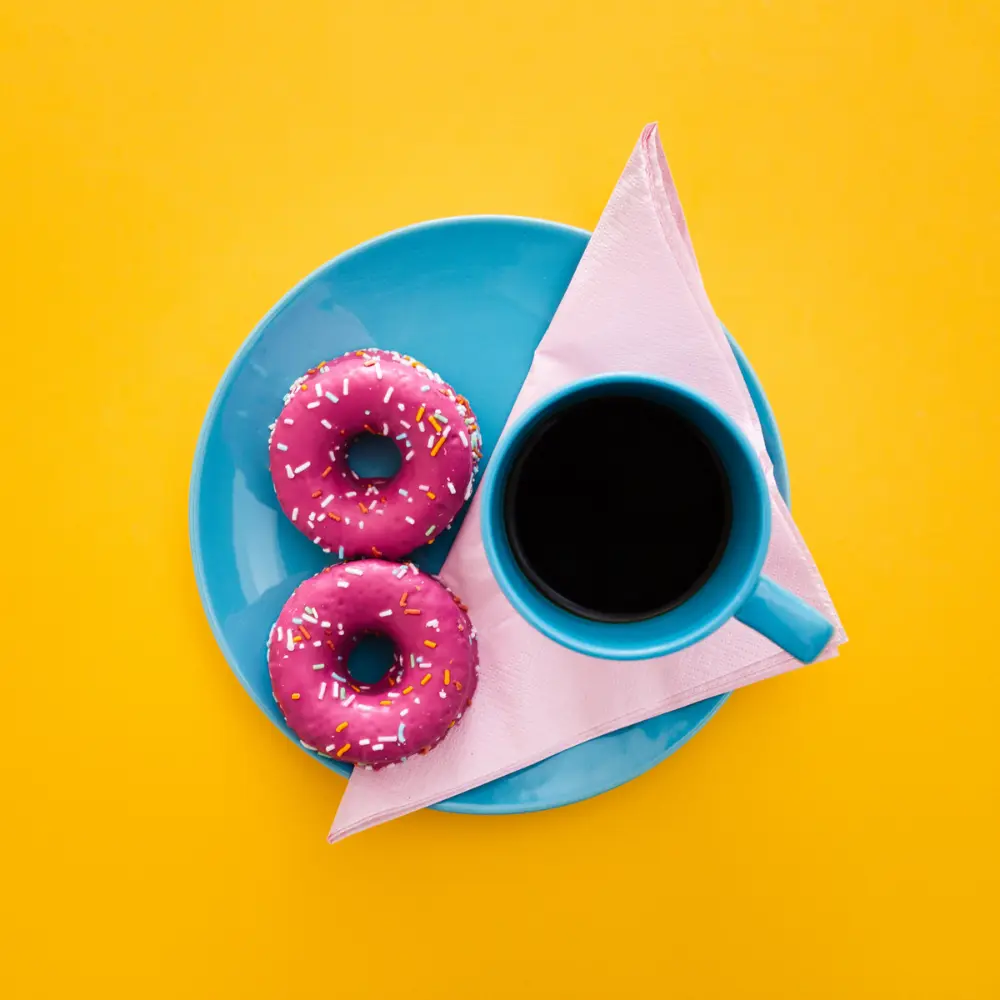 two pink donuts served with a black coffee