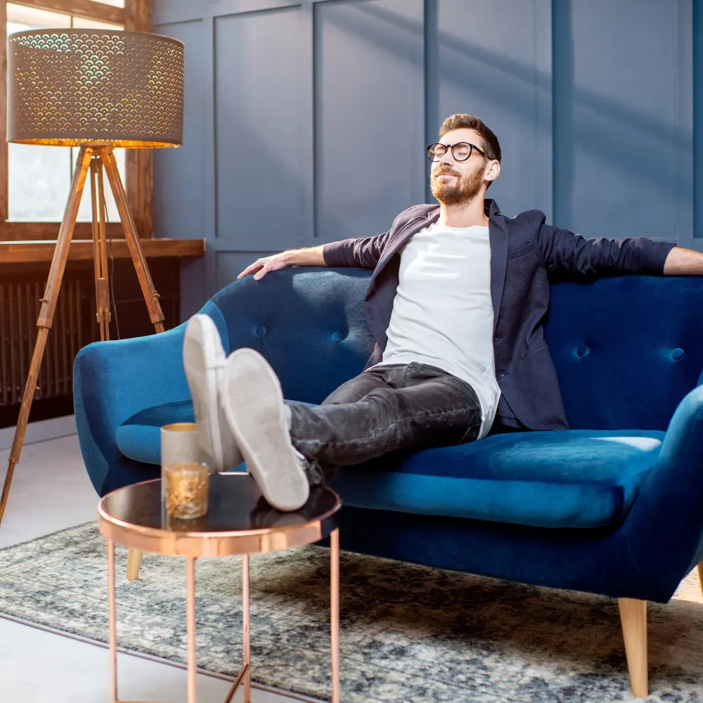 man relaxing in relief on his couch
