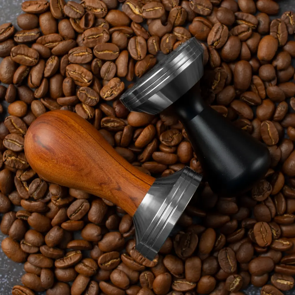 two different espresso tampers on coffee beans