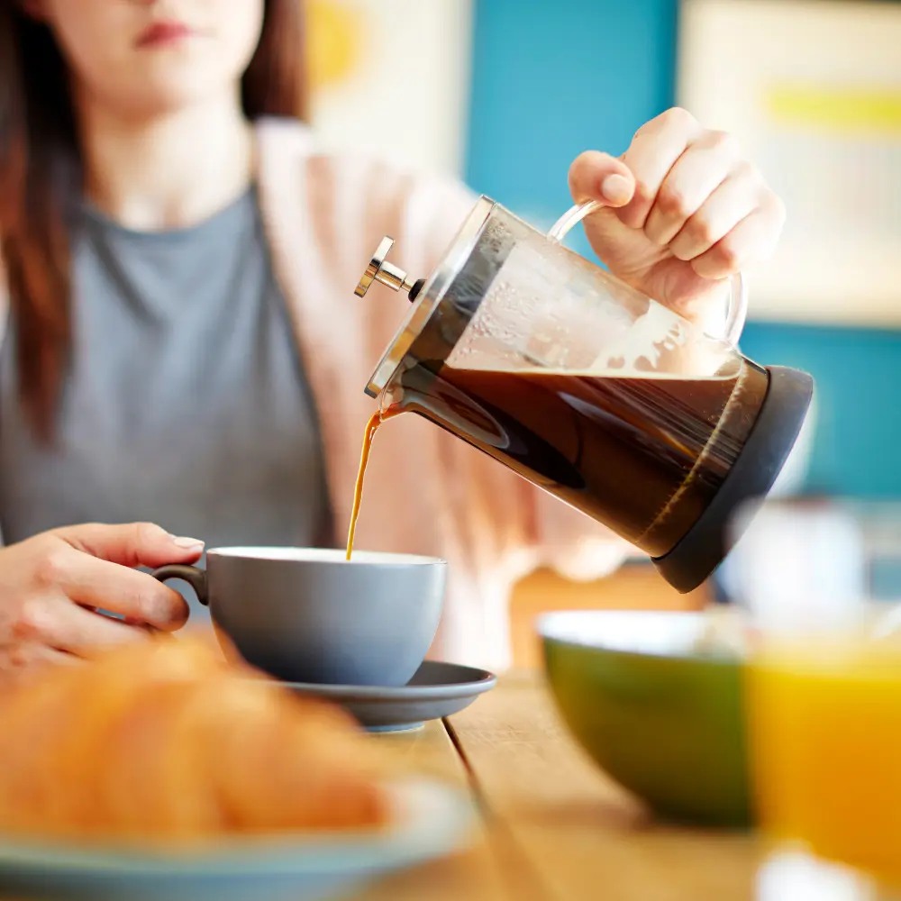 woman pouring french press coffee