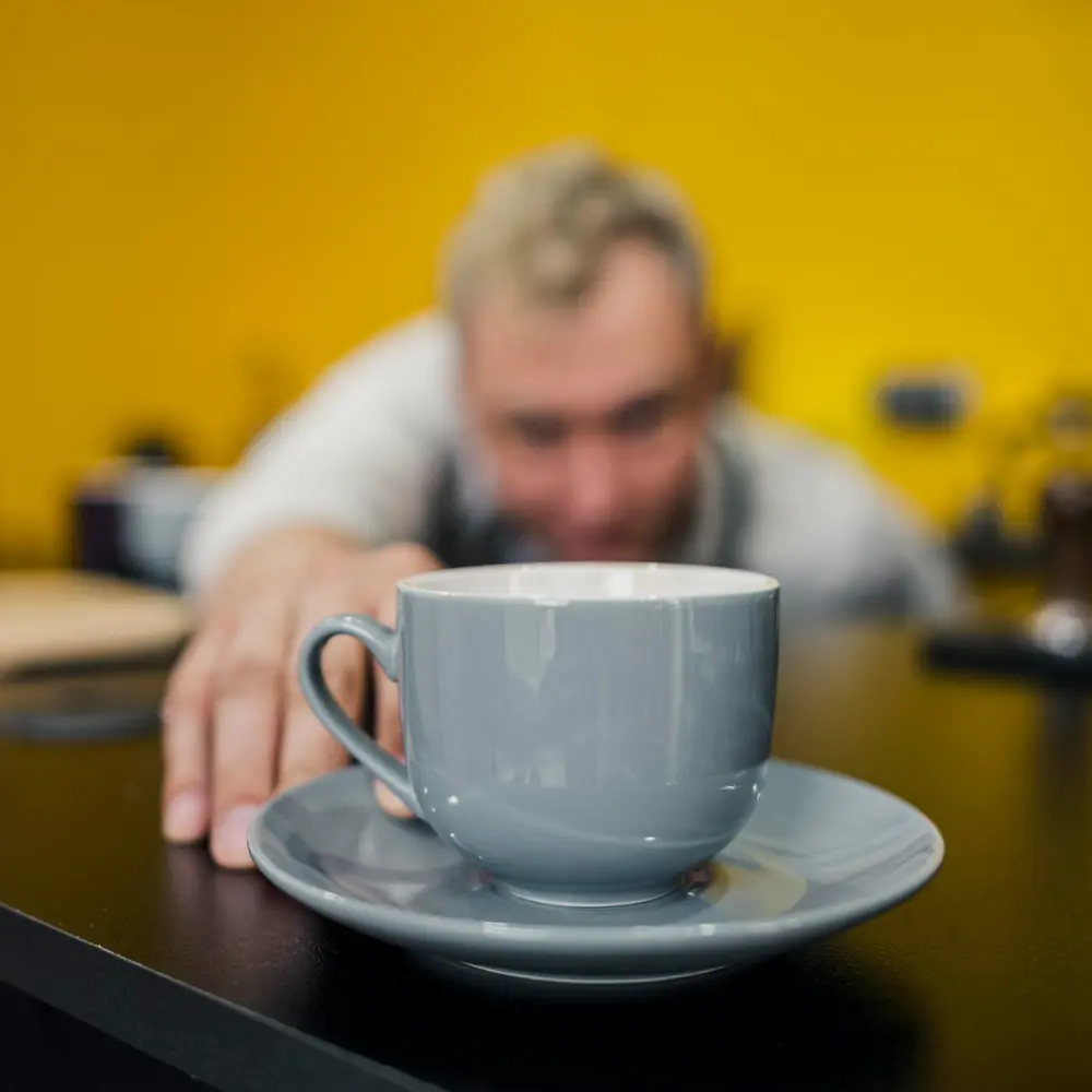 grey coffee mug with a man in the distance