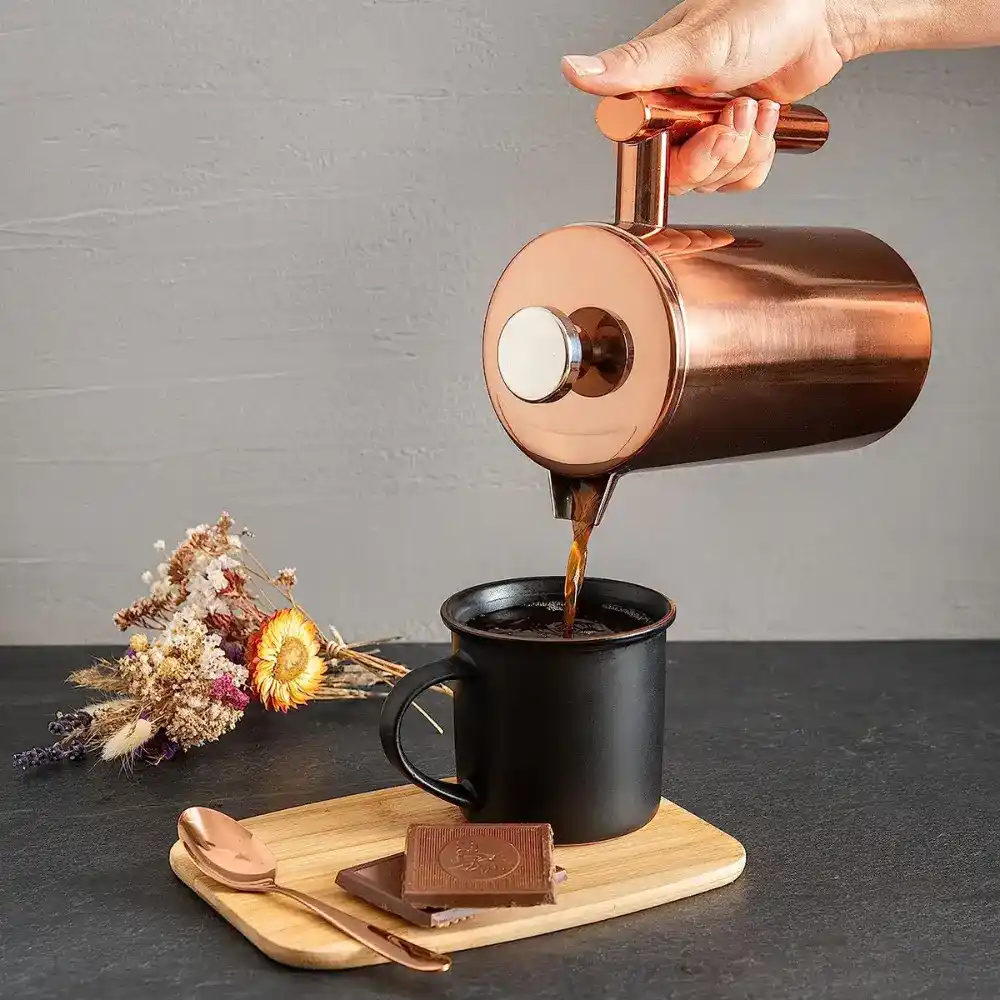 a bronze press pouring coffee