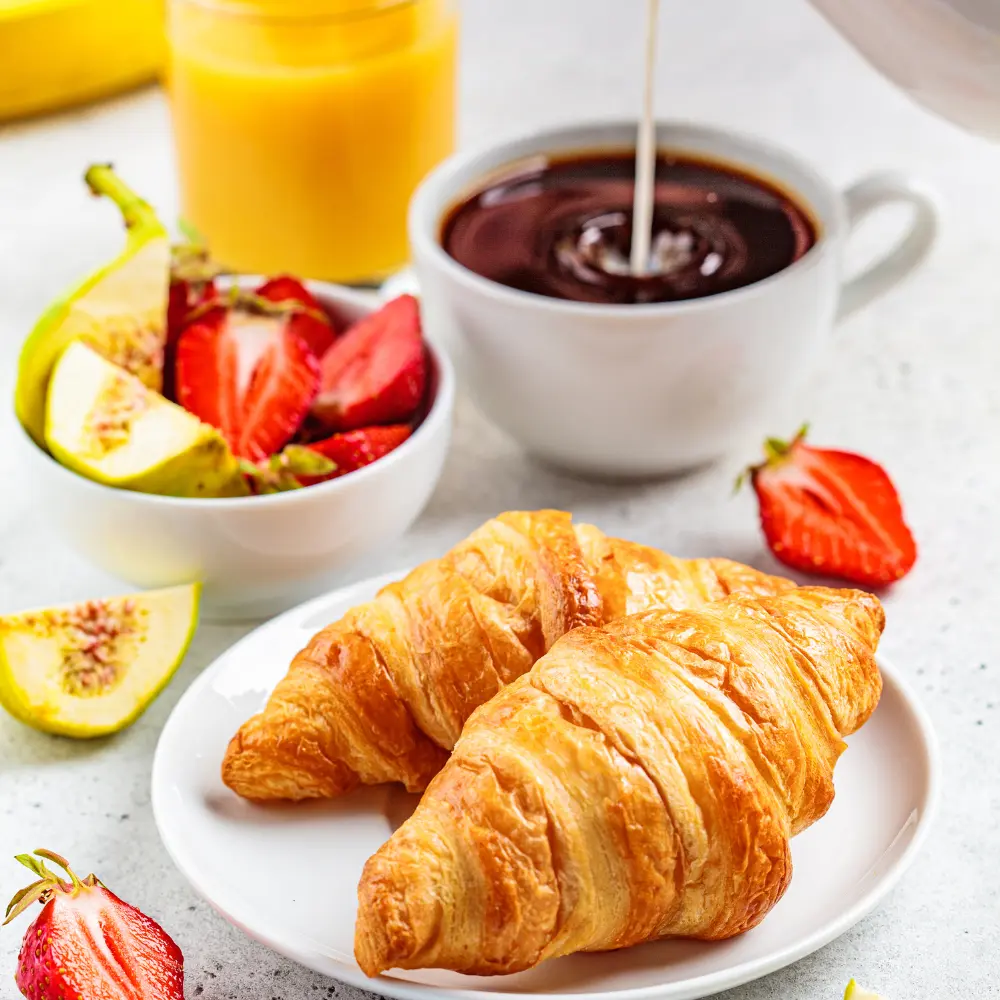 croissants served with fruit and coffee
