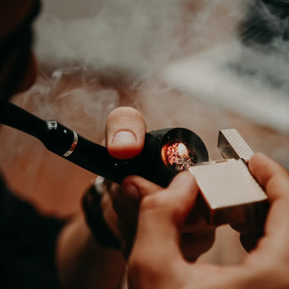 man lighting up a pipe