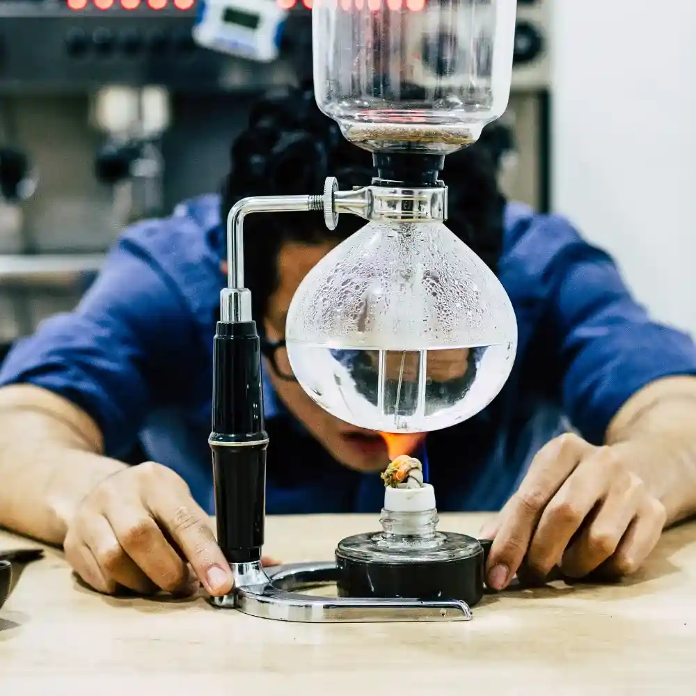 barista experimenting with siphon brewing