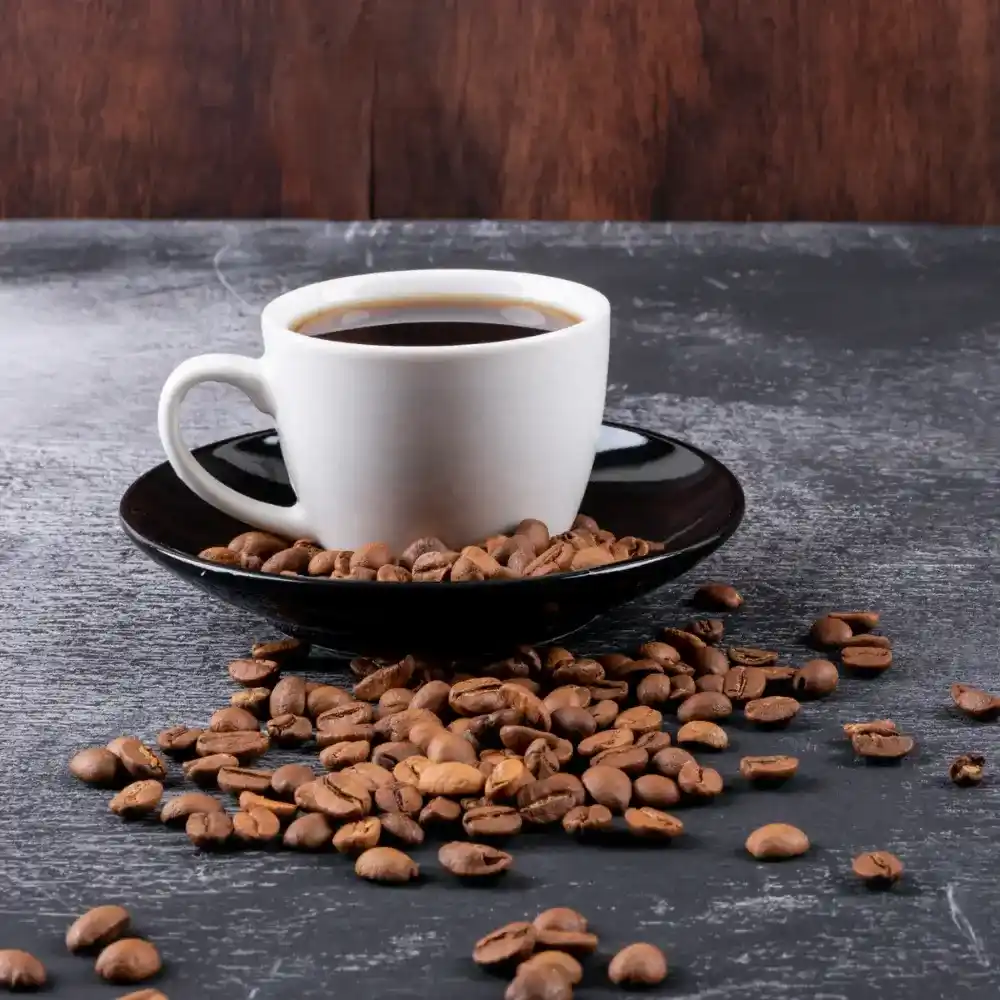 cup of coffee with coffee beans on a saucer