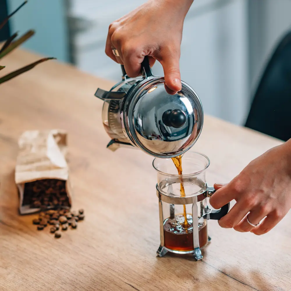barista pouring coffee out of a press